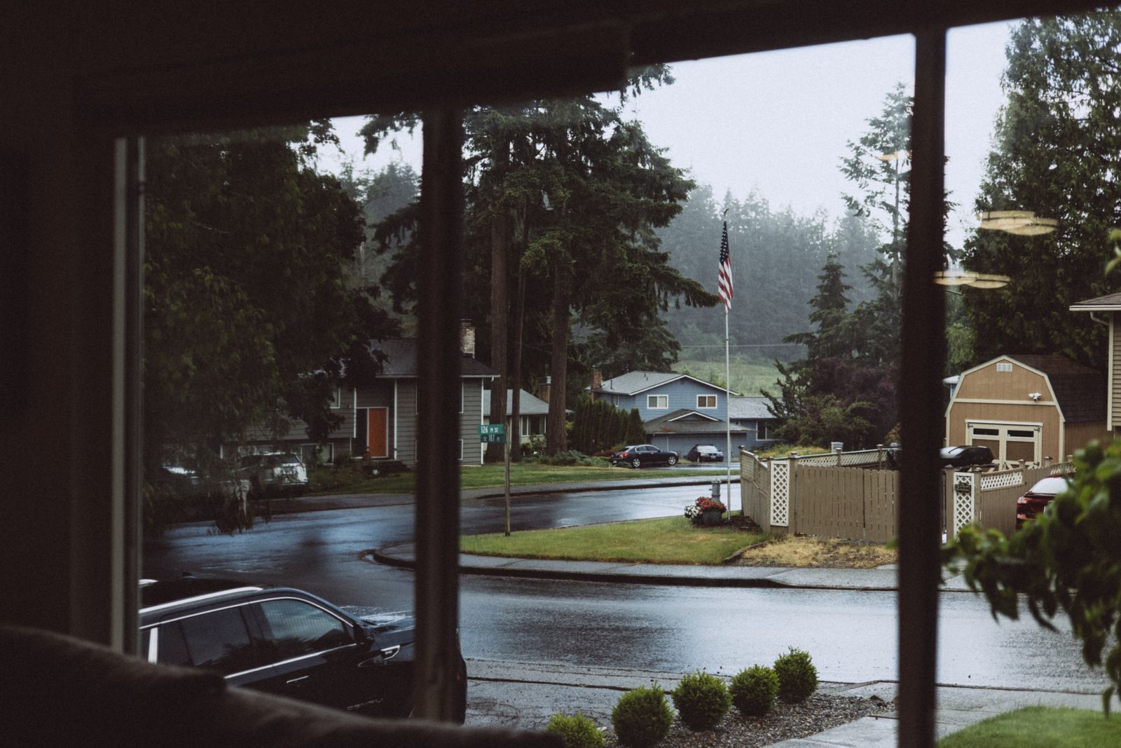 Rain falling on a suburban street seen from indoors